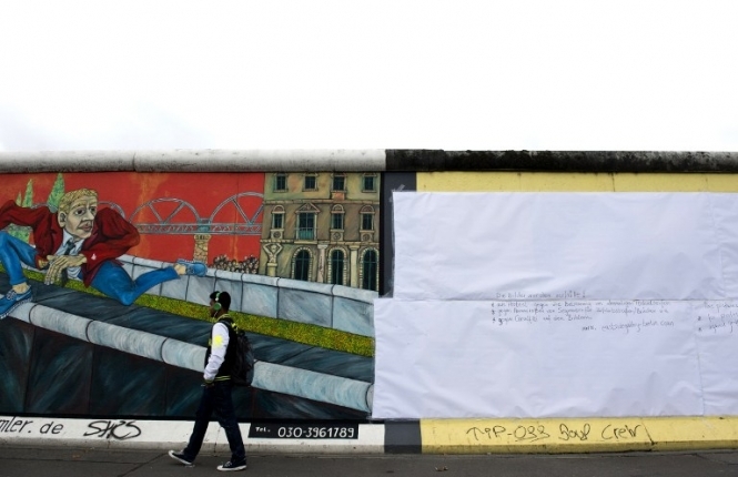 Художники почали заклеювати Берлінську стіну білим папером
