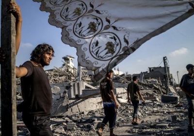 Сектор Гази, Газа, 6 серпня 2014 року. Палестинці стоять поруч зі своїми зруйнованими будинками. Конфлікт Ізраїлю та палестинців триває майже місяць. Армія Ізраїлю здійснює авіаудари по палестинській території у відповідь на ракетні обстріли з сектора Гази. Прем