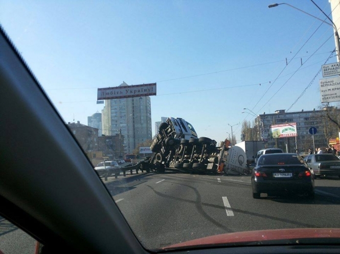 В Киеве в результате аварии перевернулась огромная фура с цистерной: есть пострадавшие, - фото 