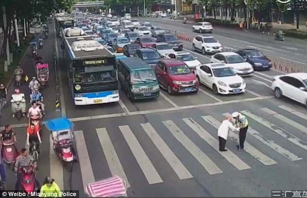 В Китае полицейский на себе перенес пожилого мужчину через дорогу - ВИДЕО