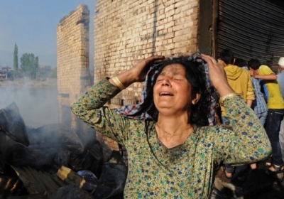 Индия, Шринагар, 29 апреля 2014. Местная жительница оплакивает свое сгоревшее жилище. Пожар в трущобах города Шринагар разрушил около 20 домов и магазинов. Фото: АFР