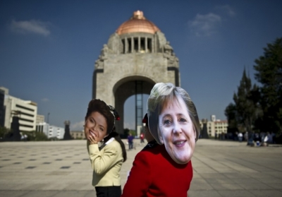 Люди в масках президента Бразилії Ділми Руссефф і канцлера Німеччини Ангели Меркель. Фото: AFP