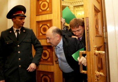 Опозиціонери виганяють батька і сина Табалових із сесійної зали. Фото: АFP