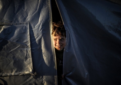Турция, Сирия. Курдская девушка рано утром смотрит из палатки в лагере для беженцев в Суруч. 21 октября 2014 Фото: АFР
