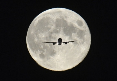 Пасажирський літак на підході до посадки в аеропорту Хітроу на тлі повного місяця, 23 вересня. Фото: Reuters
