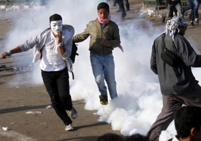 Єгипет, Каїр: Демонстранти тікають від сльозогінного газу під час зіткнень з поліцією 28 листопада 2012. Фото: AFP