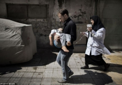 Чоловік виносить свою дитину з лікарні, Алеппо, Сирія.  Фото: AFP