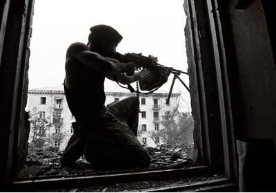 Чеченский боец обстреливает позиции российских войск. Август 1996 года Фото: Christopher Morris / VII