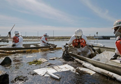Работники разворачивают заграждения, чтобы попытаться остановить дальнейшее распространение нефти в водно-болотные угодья у города Хантингтон-Бич, США, 3 октября 2021 Фото: AP Photo / Ringo H.W. Chiu