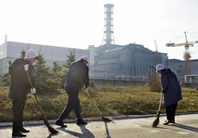 12 квітня 2006 робочі змітають радіоактивний пил перед саркофагом, що закриває пошкоджений 4-й реактор Чорнобильської АЕС. Через високий рівень радіації бригади працюють всього по кілька хвилин. Фото: AFP
