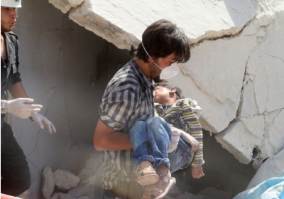 Сирія, Халеб: сирійський рятувальник несе тіло дитини яка постраждала внаслідок вибуху бомби в північному місті Алеппо 27 вересня 2014. За словами сирійського центру захисту прав людини, принаймні, 180 000 чоловік були вбиті з початку сирійського конфлікту (березнь 2011р.). Фото: АFР