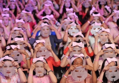 Люди одягають маски для обличчя в Тайбеї, 28 липня 2013. У заході взяли участь 1213 осіб побивши світовий рекорд.