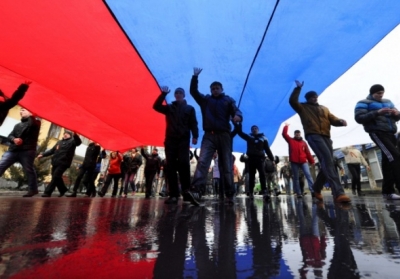 Проросійські демонстранти несуть гігантський російський прапор,  Сімферополь 27 лютого 2014. Фото: AFP