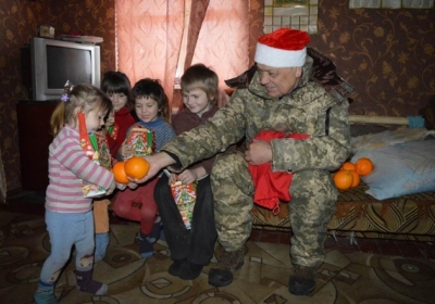 Москаль у шапці Діда Мороза приніс дітям у фронтовій зоні подарунки, - фото