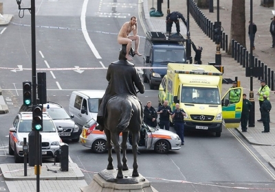 Номінація «Кращий новинний фотограф»: голий чоловік сидить на голові статуї герцога Кембриджського Георга, 23 листопада 2012. Фото: Justin Tallis / AFP