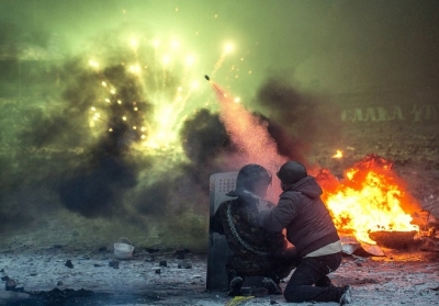 Украинский протестующие стреляют петардами между горящих шин во время массовых акций протеста на улице Грушевского в Киеве против "драконовских законов", 22 января, 2014 г. Фото: Vladislav Sodel/Kommersant Photo via Getty Images